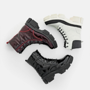 Stylish leather lace-up boots in black, white, and red on a white background.